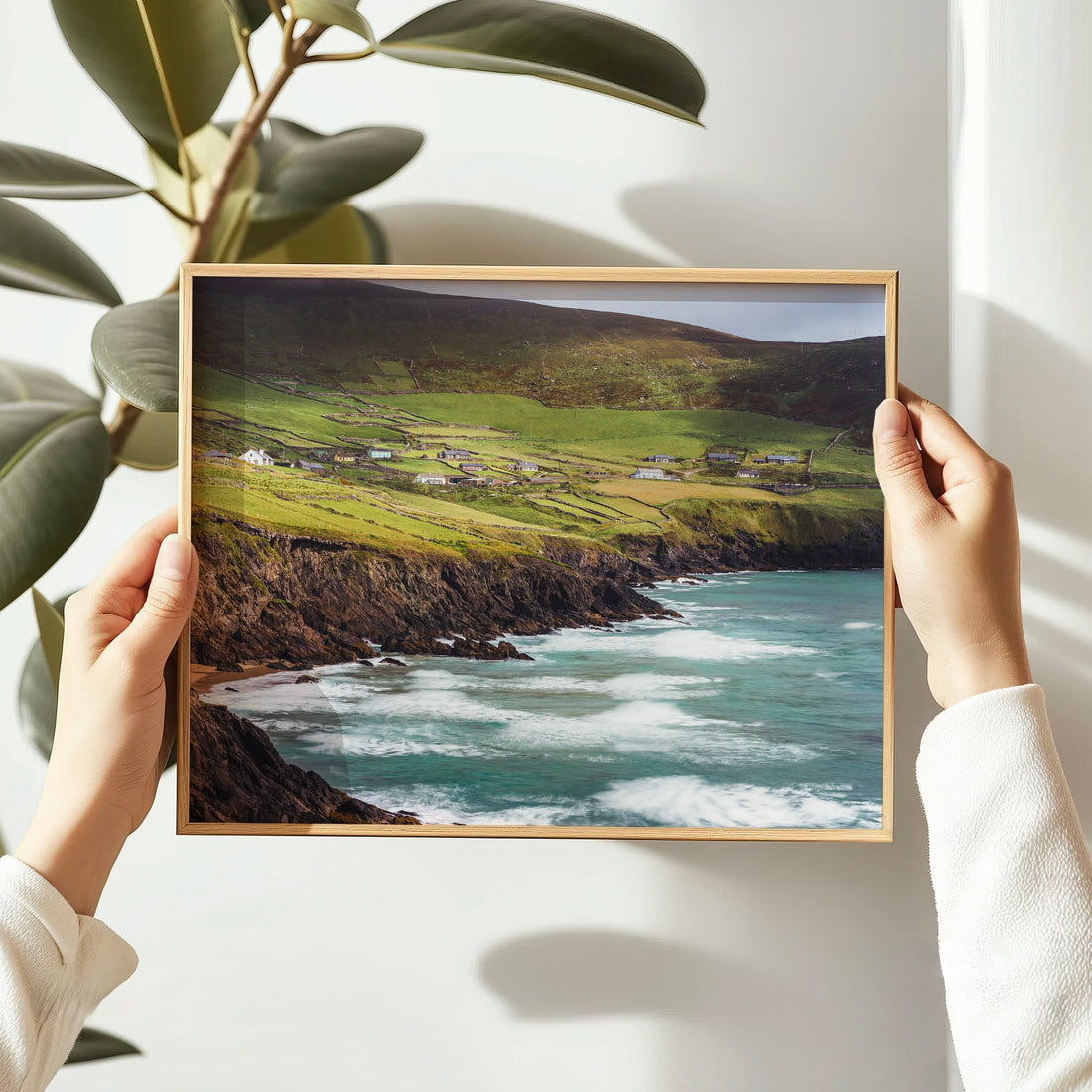 Holding a framed photo print of Coumeenoole Beach with dramatic cliffs and Atlantic surf