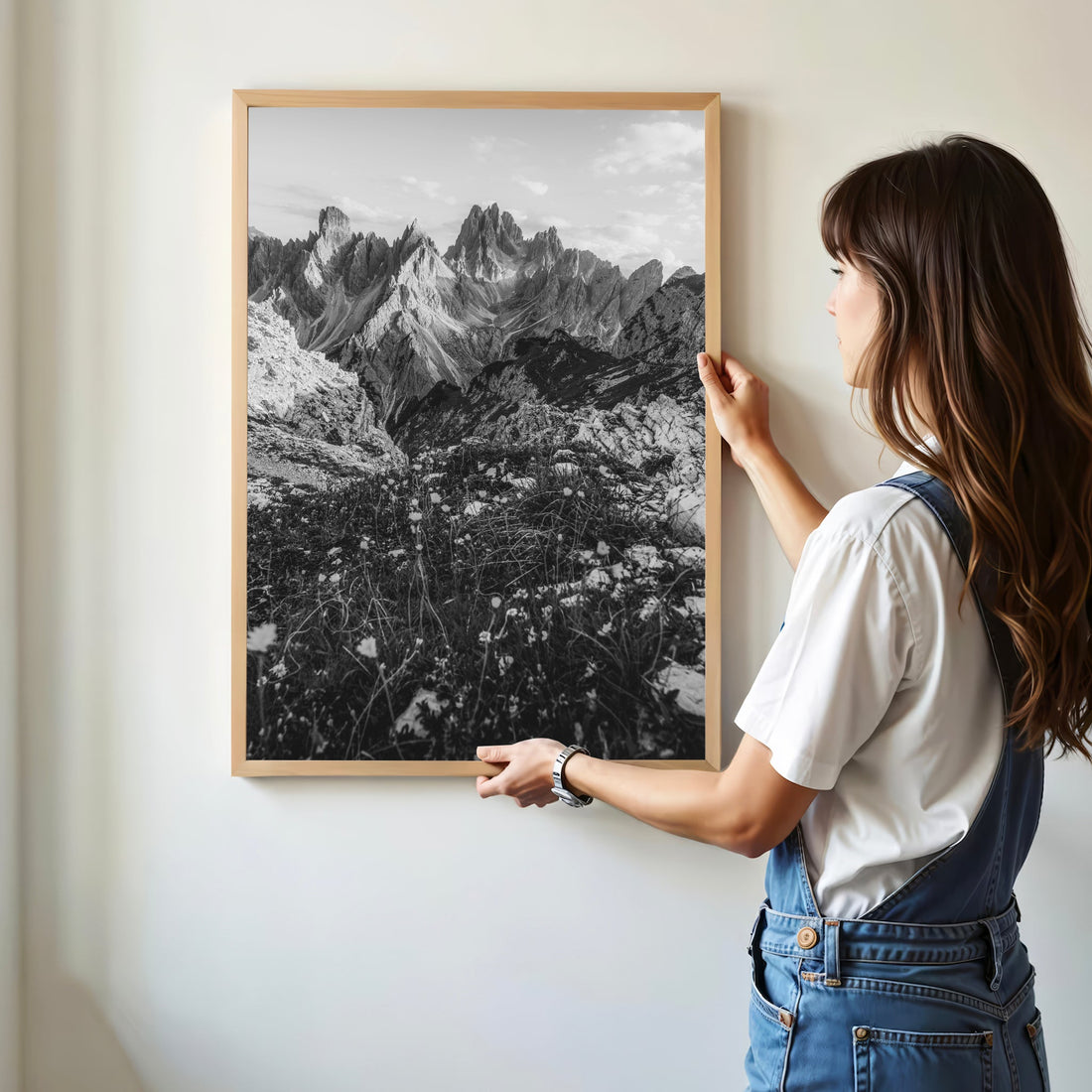 Woman holding a black and white Cadini di Misurina print in a minimal modern home.