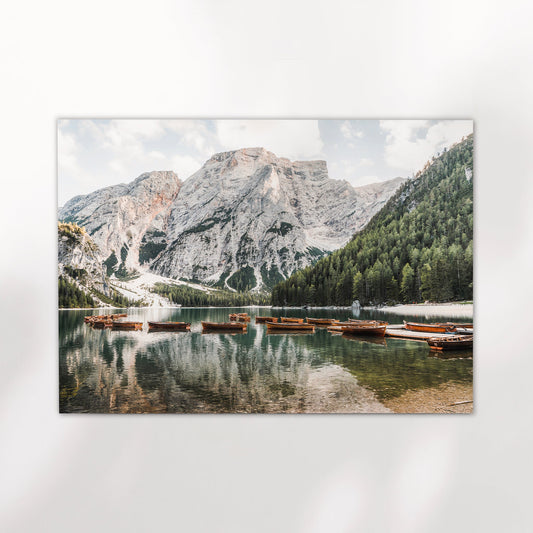 Dolomites photo print showing wooden boats floating peacefully on crystal-clear Lago di Braies with towering alpine mountains.
