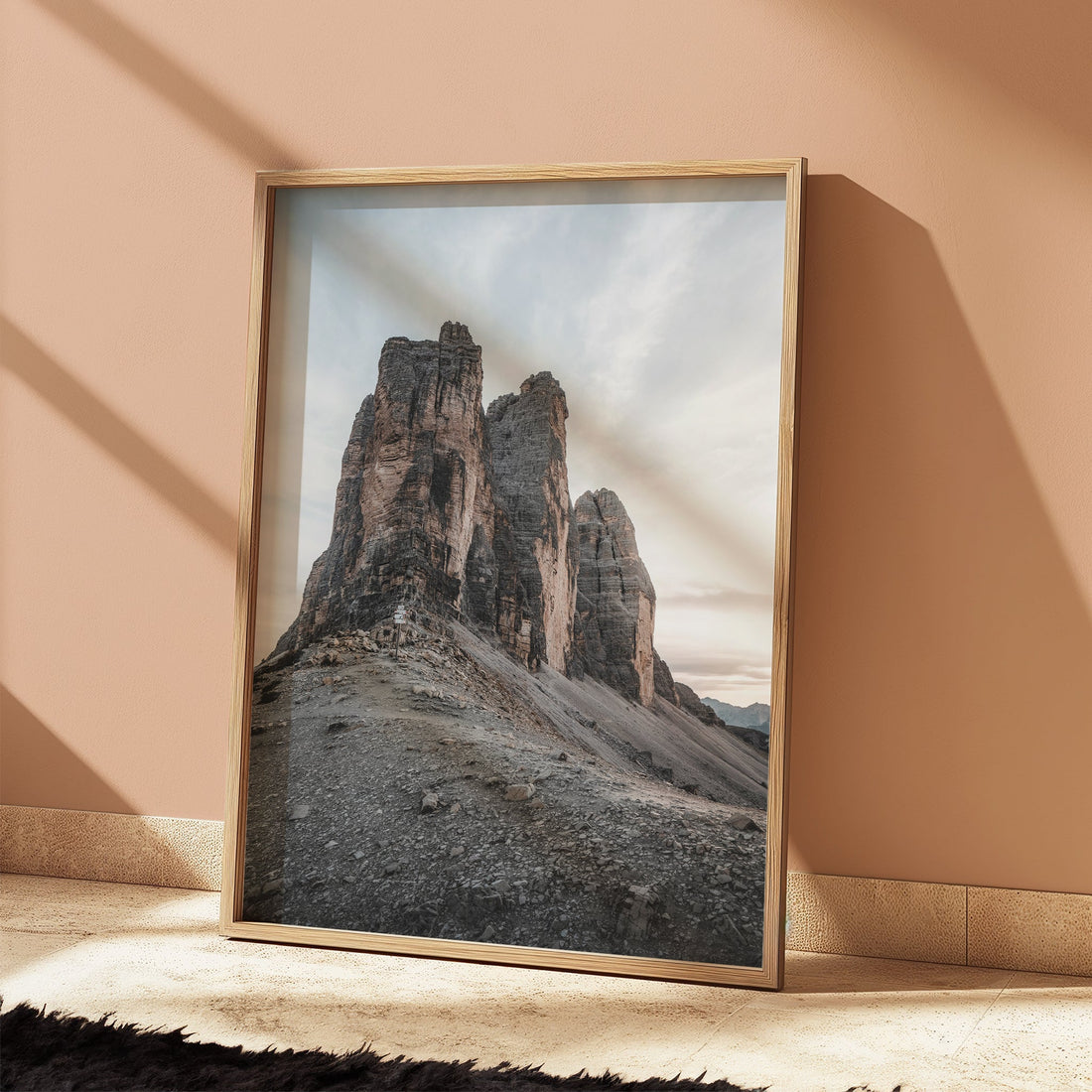 Tre Cime mountain print against peach coloured wall with shadows