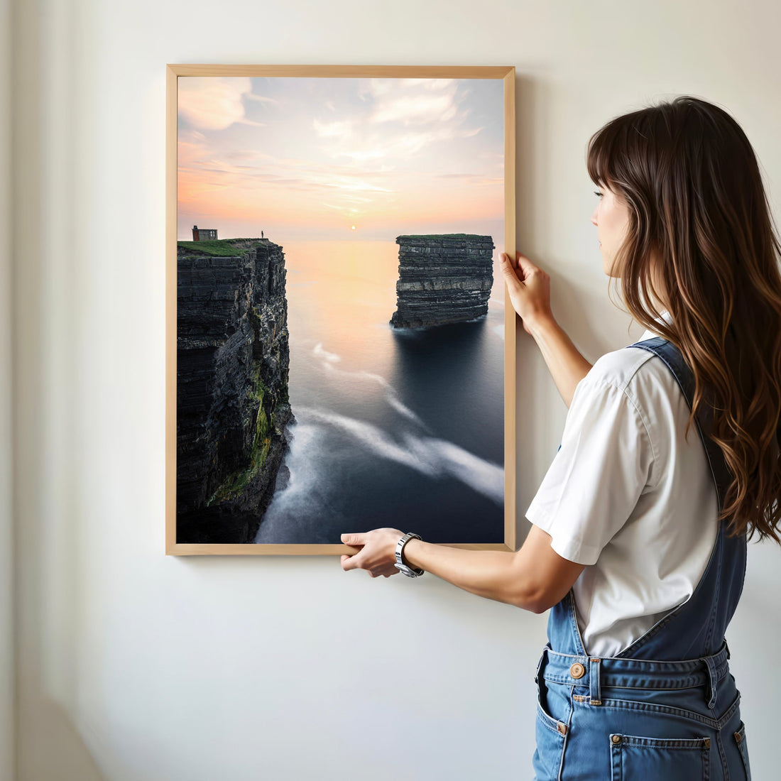 Woman hanging Downpatrick Head coastal photography print in modern frame.