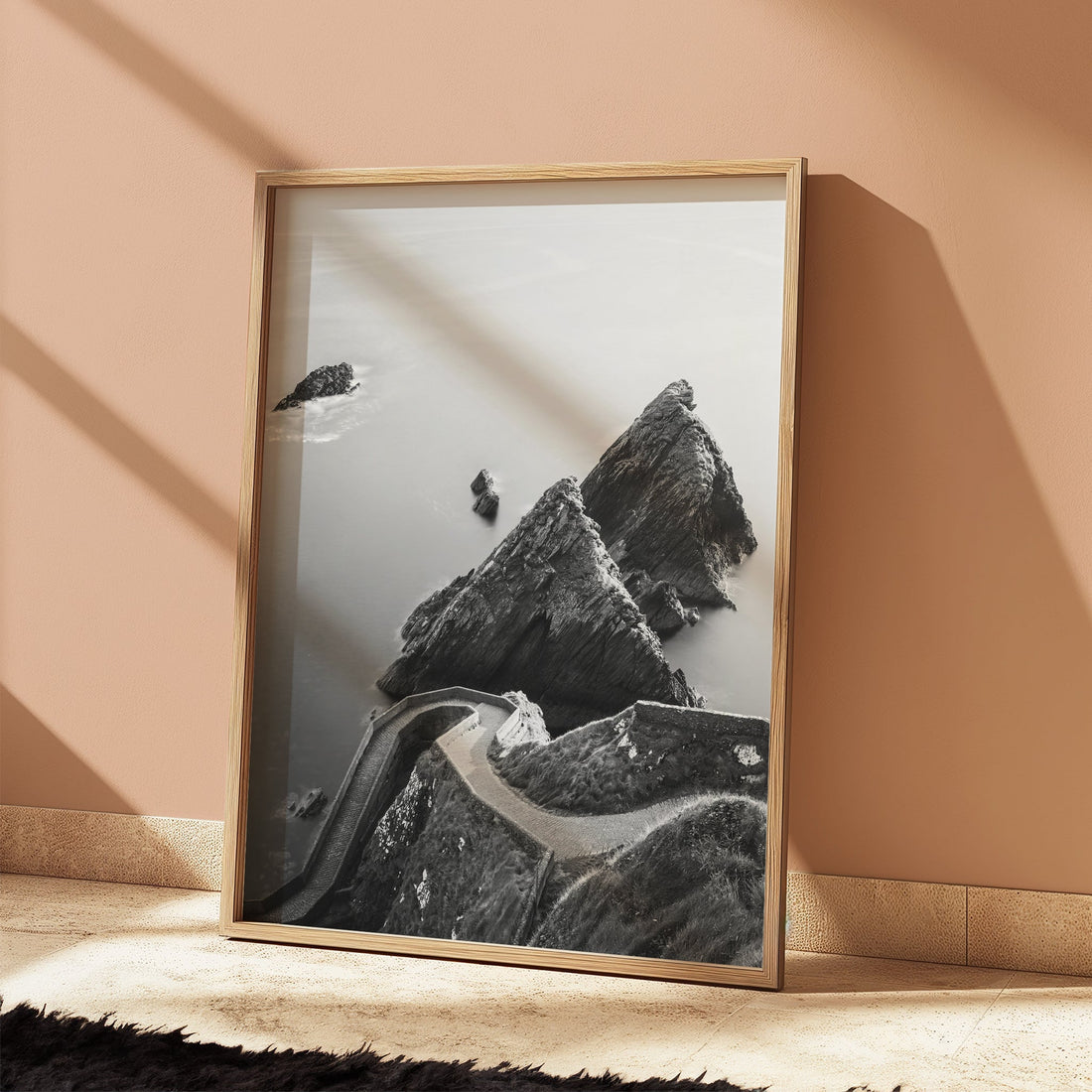 Framed Dunquin Pier photo leaning against a peach wall