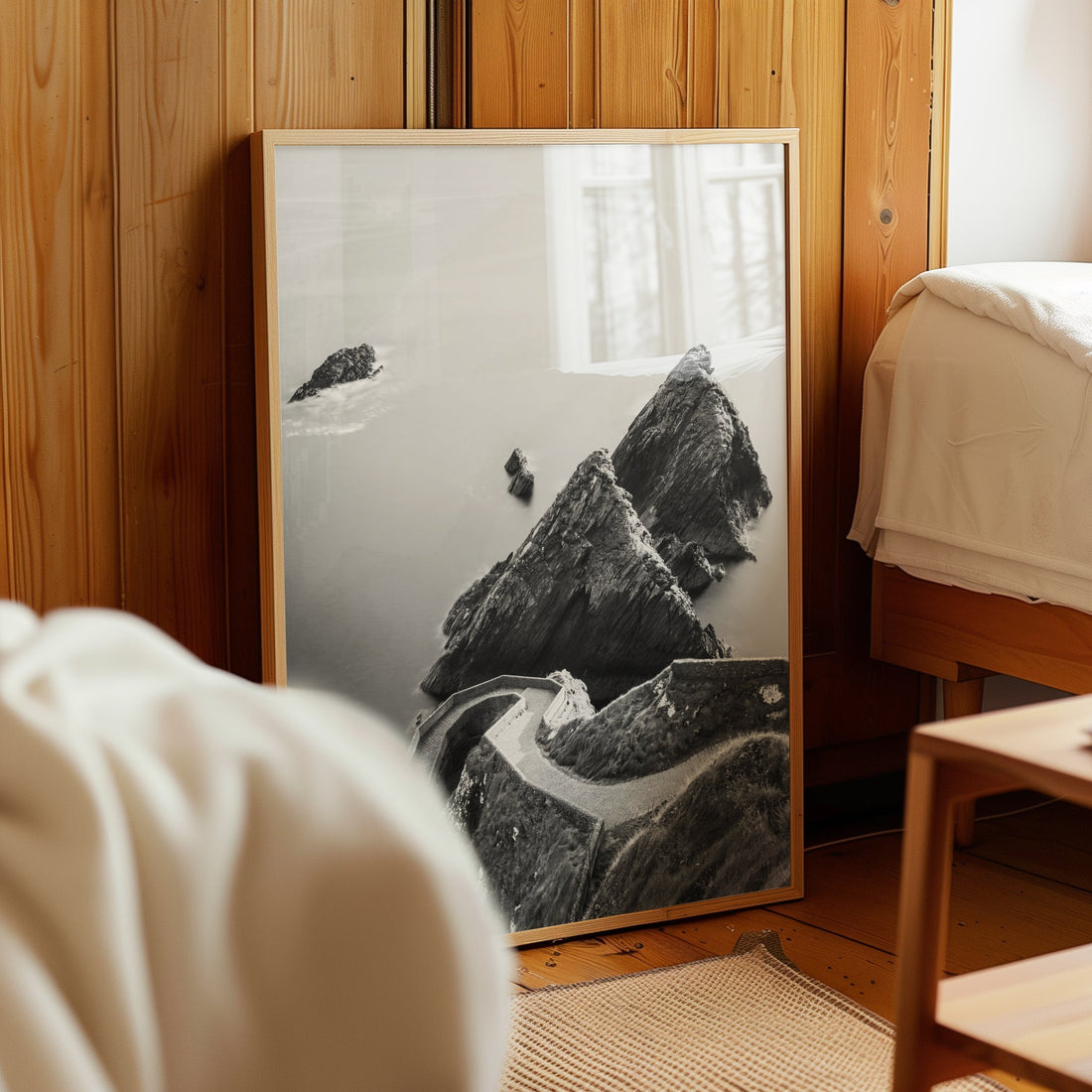 Framed Dunquin Pier artwork leaning against a wooden bedroom wall