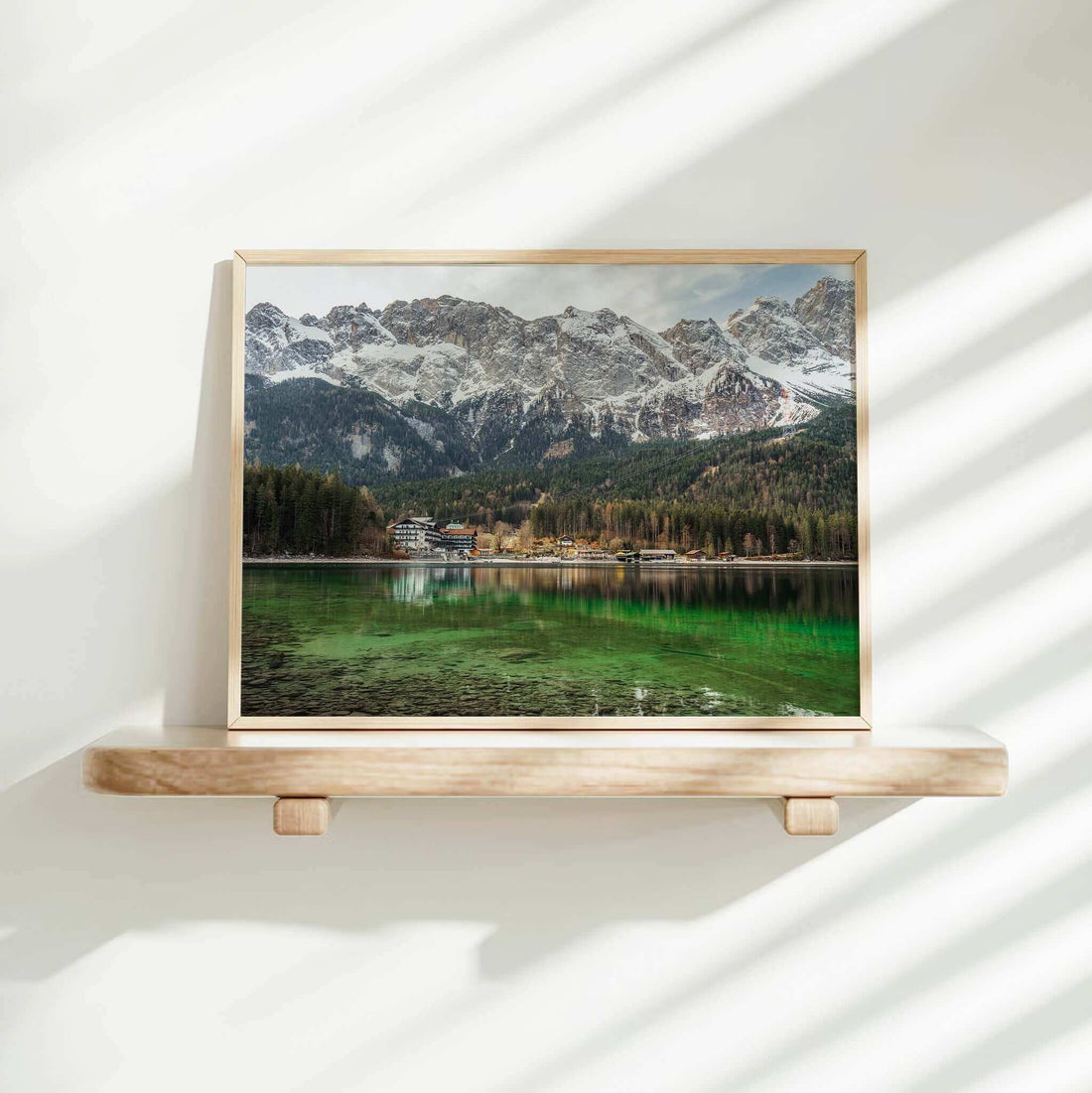 Eibsee framed art print on a shelf with green lake and dramatic alpine backdrop