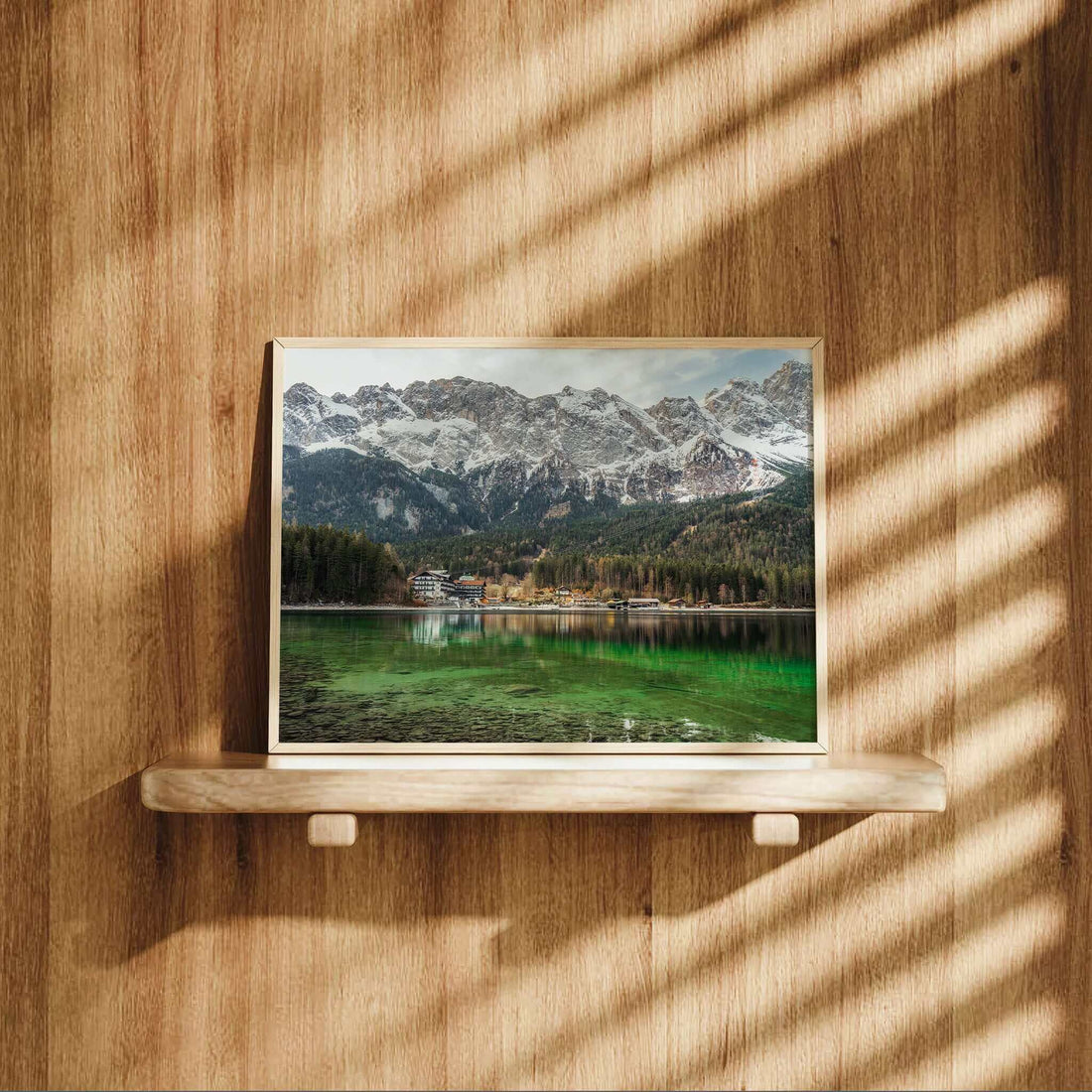 Eibsee lake art print on a wooden shelf with sunlight and shadows