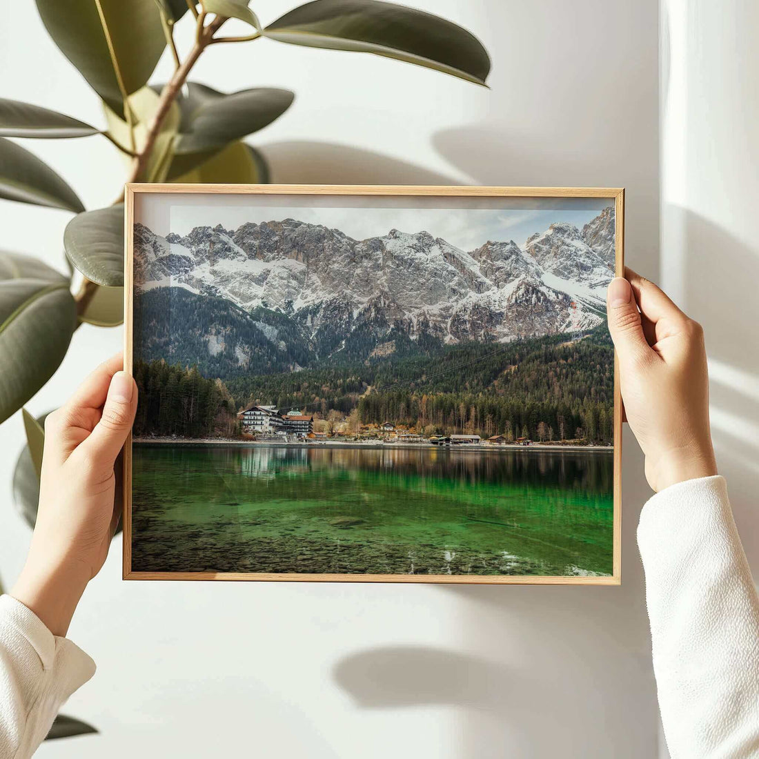 Person holding a framed Eibsee print with alpine lake and forest