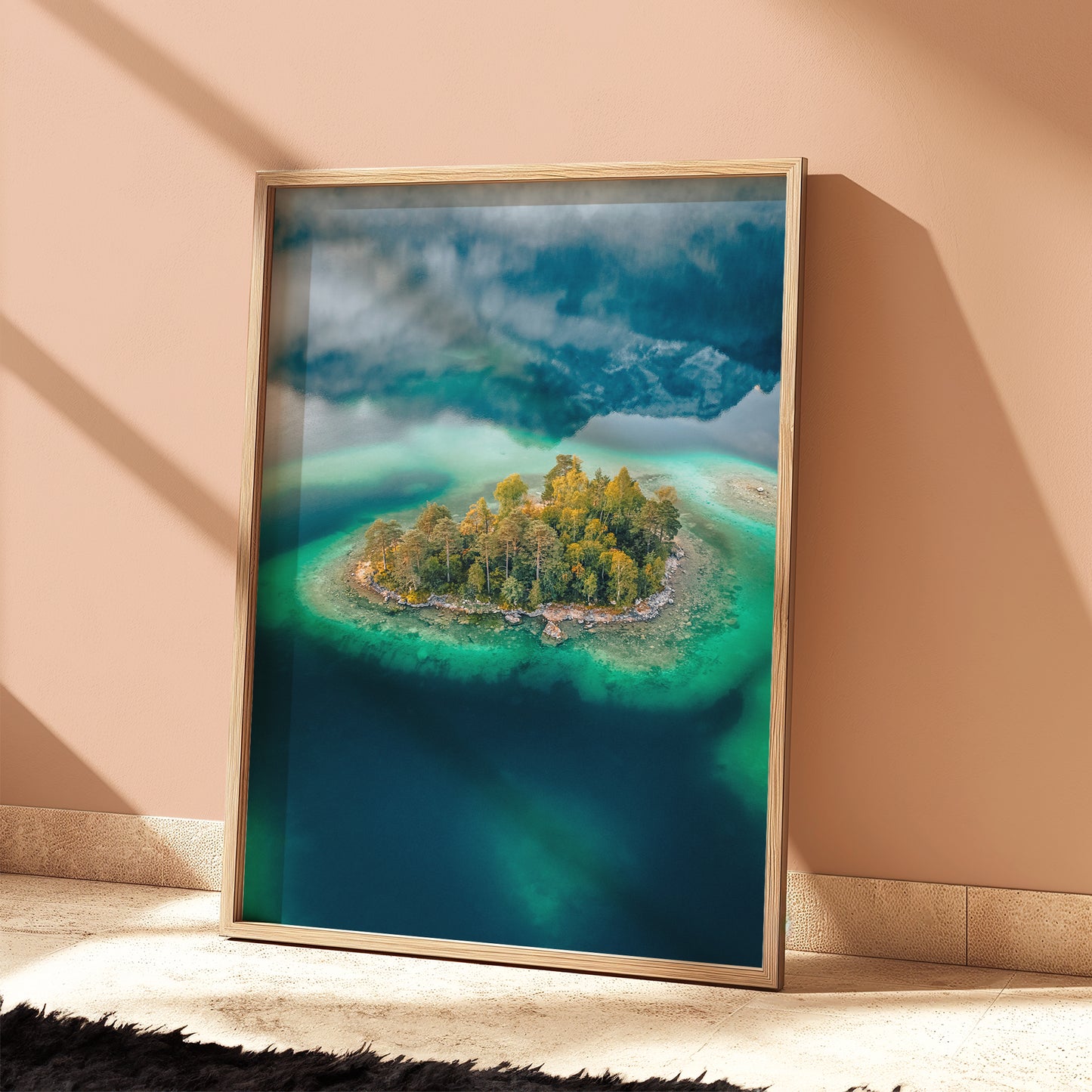 Overhead view of island in Eibsee surrounded by emerald and teal lake water