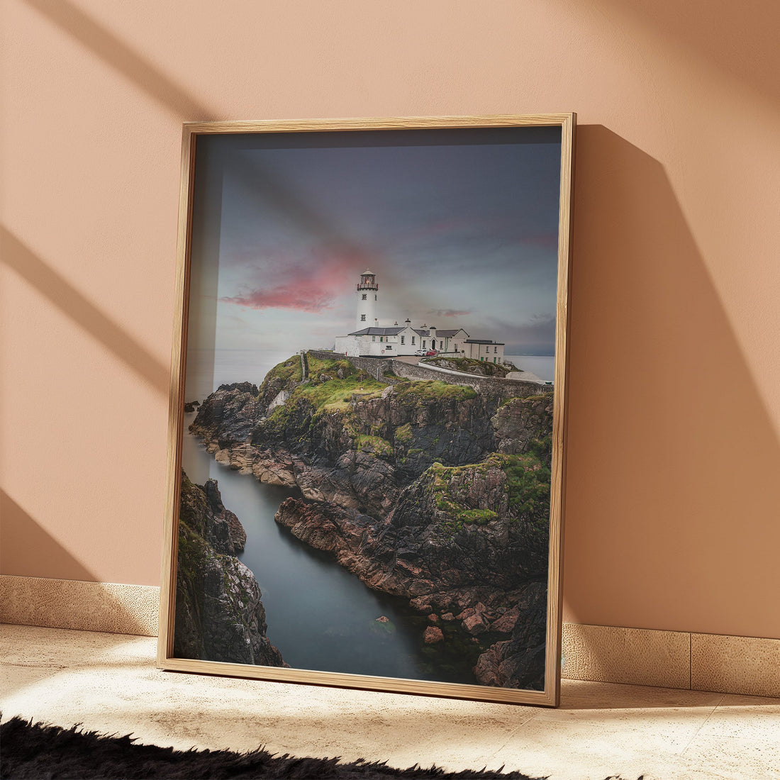 Sunset Fanad Lighthouse art print leaning against peach wall