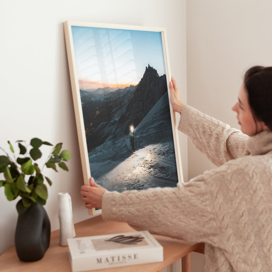 Woman adjusting alpine mountaineering print showing glacier path and lights