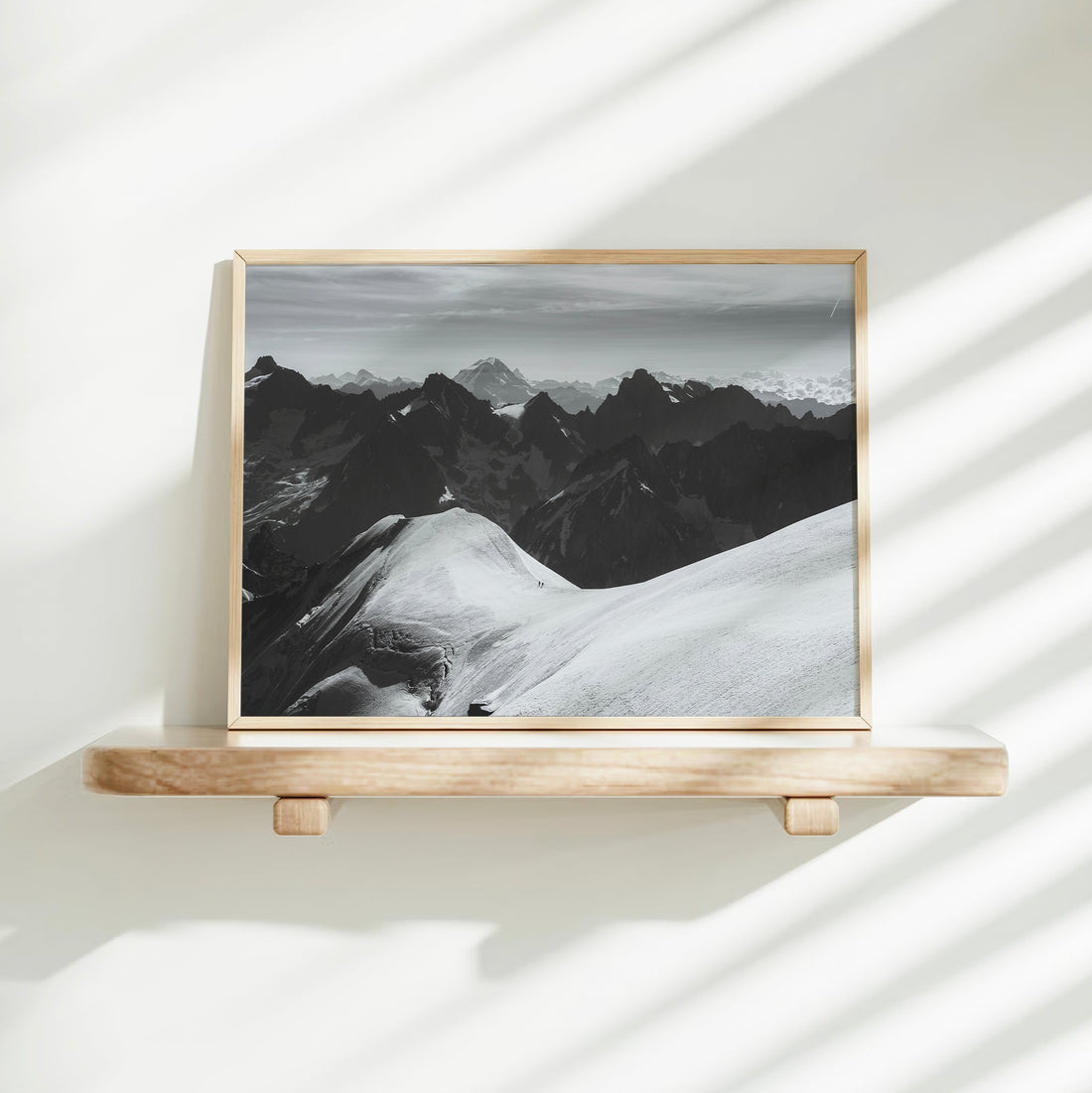 Elegant black and white photography print of climbers navigating high-altitude ridgelines in the Alps.