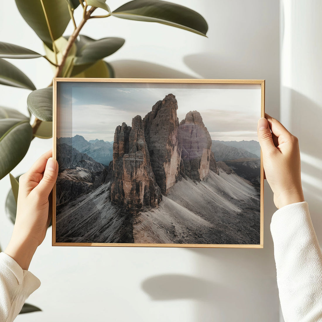 Hands holding framed Tre Cime Dolomites photo print, ideal for gifting or small spaces