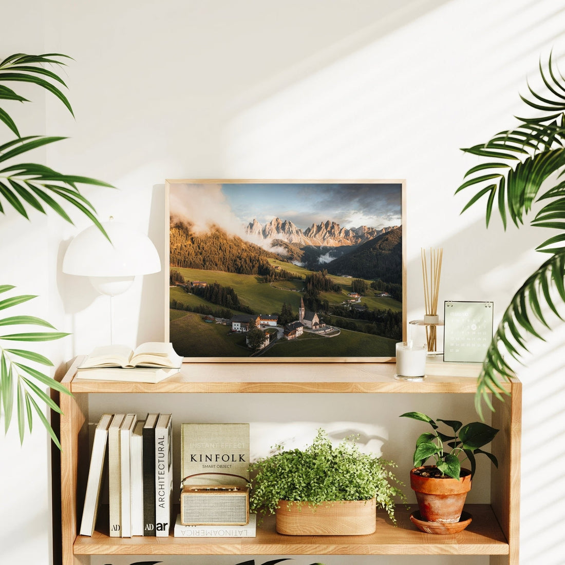 Dolomites wall art displayed on shelf with plants and natural light