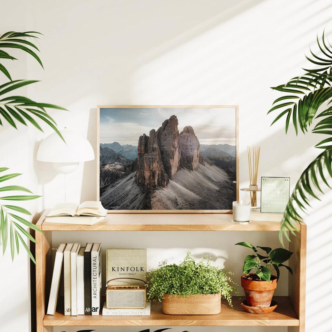 Framed Tre Cime landscape print on shelf with houseplants and natural lighting