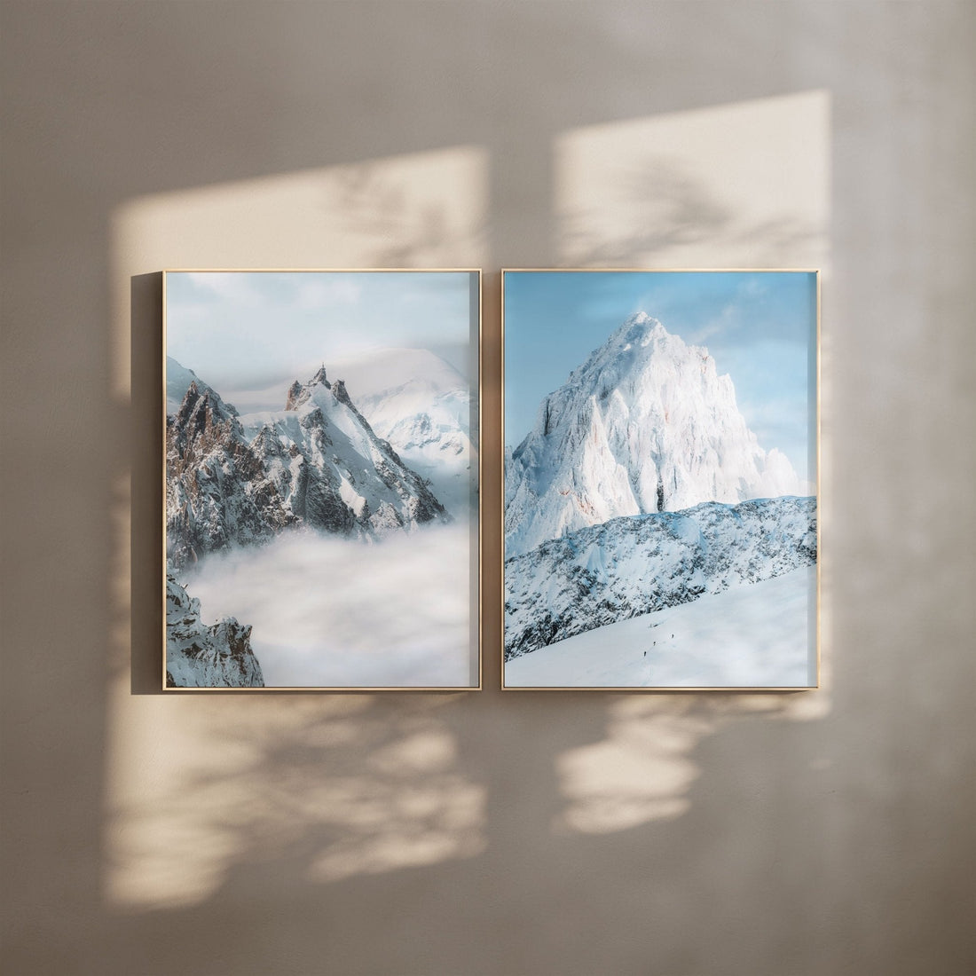 Framed prints of Aiguille du Midi and Grands Montets with soft light reflections on a wall.