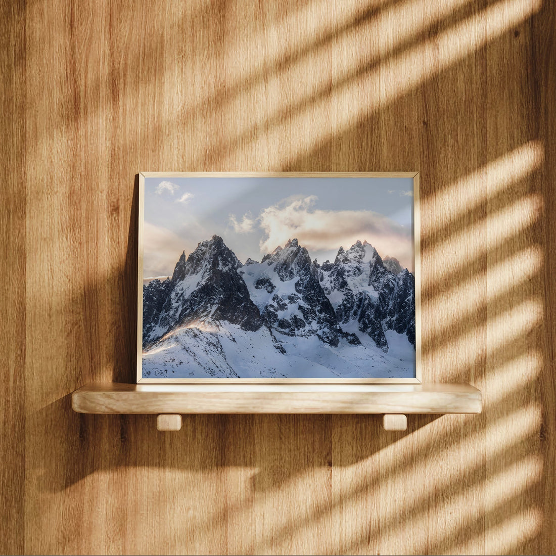 Chamonix peaks wall art displayed on wooden shelf with afternoon light