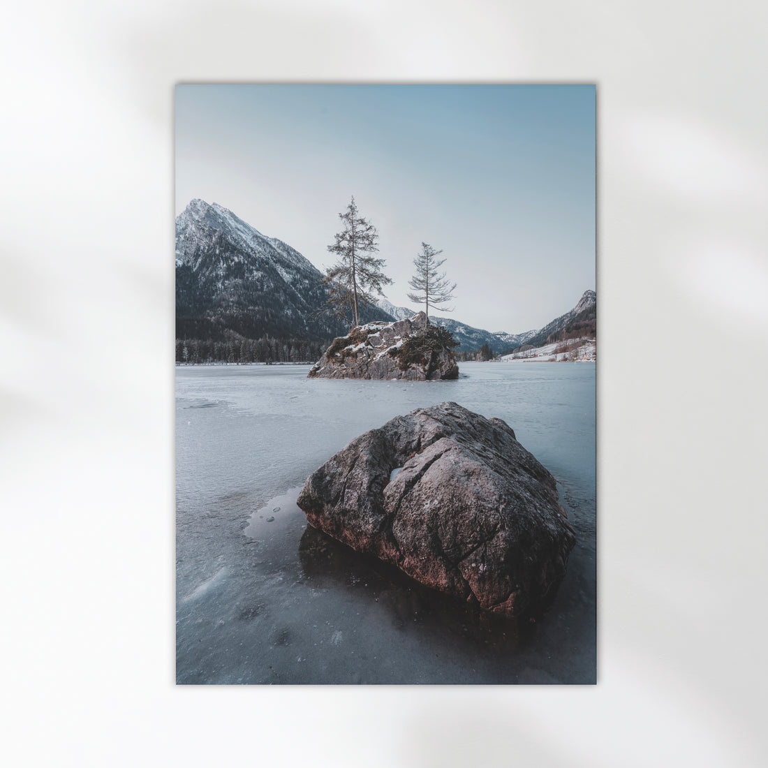 Frozen Hintersee lake with pine trees and snowy mountains in the Bavarian Alps