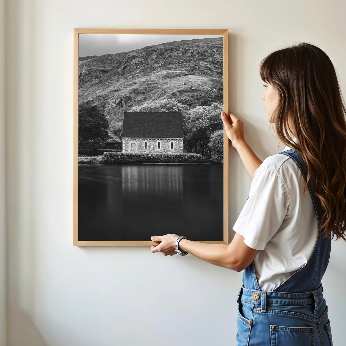 Woman hanging Gougane Barra black and white chapel print on wall
