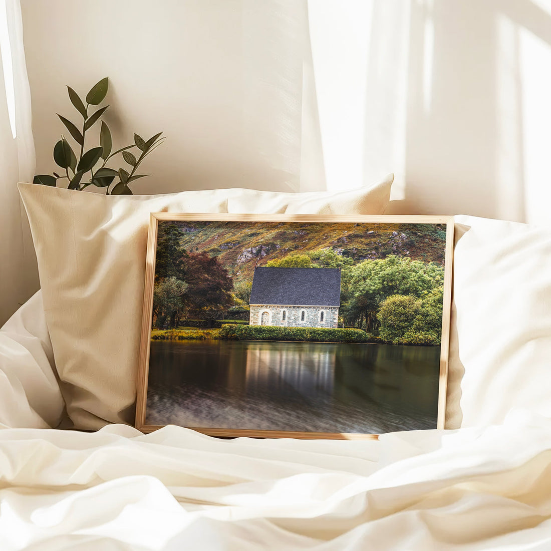 Framed Gougane Barra chapel photo resting on bed with natural light