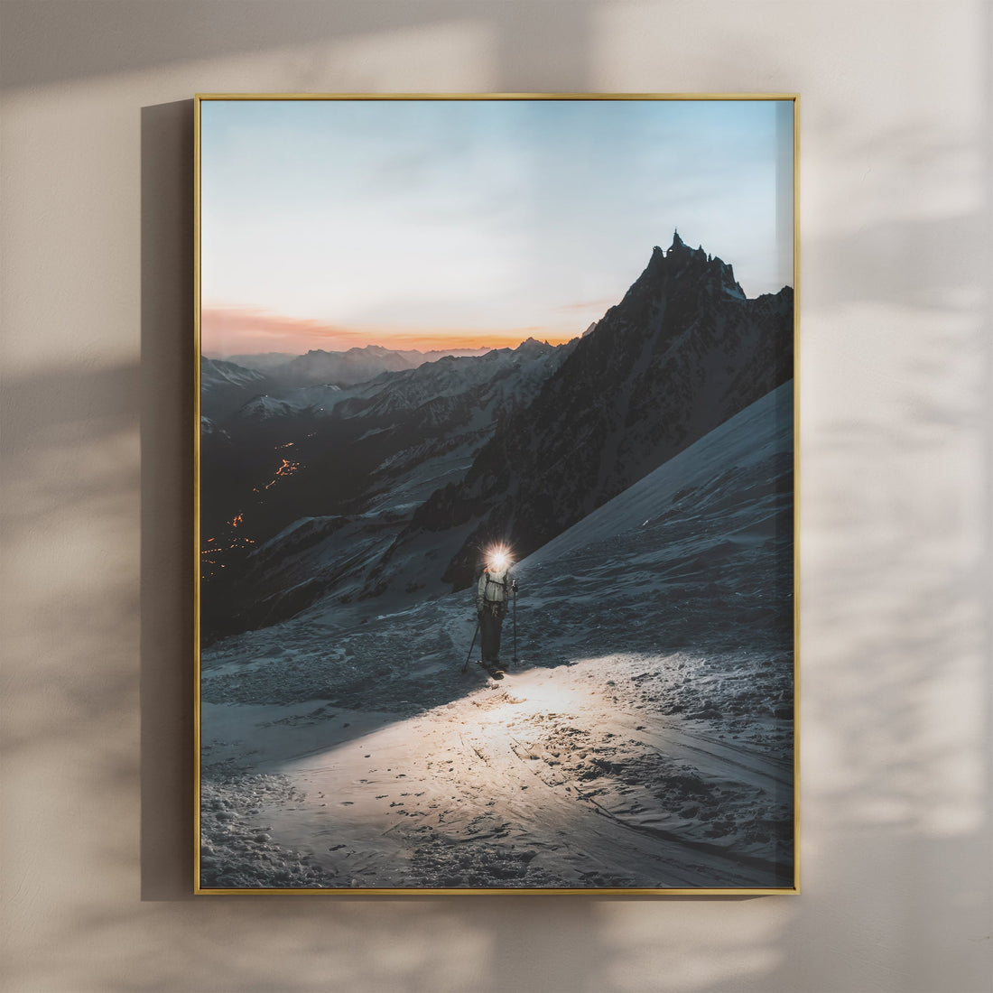 Mountaineer climbing Grands Mulets glacier at sunset with glowing headlamp