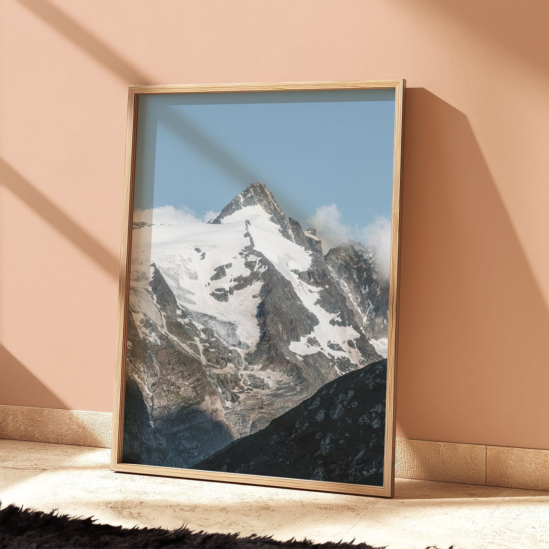 Framed Grossglockner Austria photo print styled in peach-toned interior.