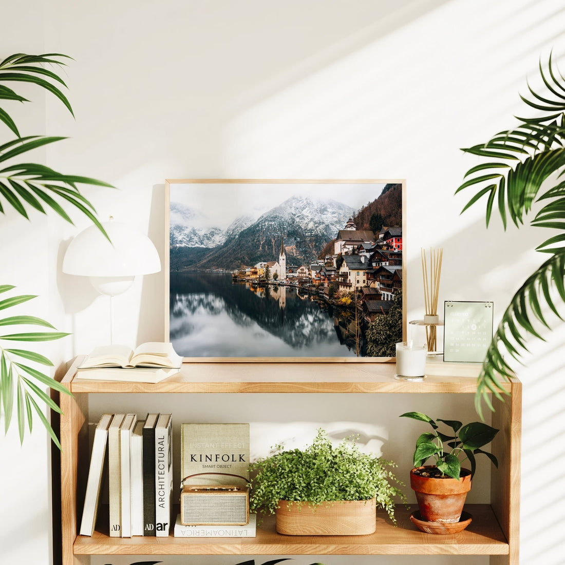 Wall art print of Hallstatt in a stylish home interior setting with books and greenery.