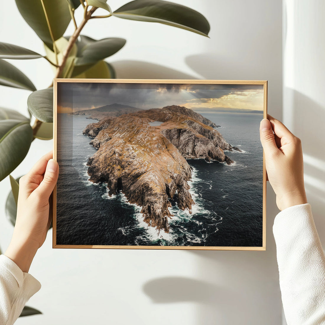 Handheld framed print of Sheep’s Head seascape in warm natural light.