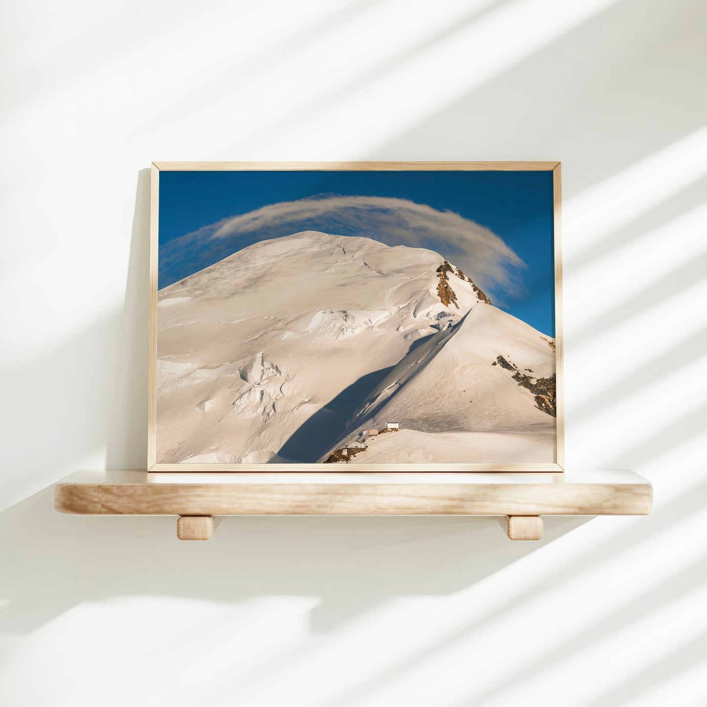 High altitude landscape photo of the Mont Blanc summit route, showcasing snow ridges beneath a lenticular cloud.
