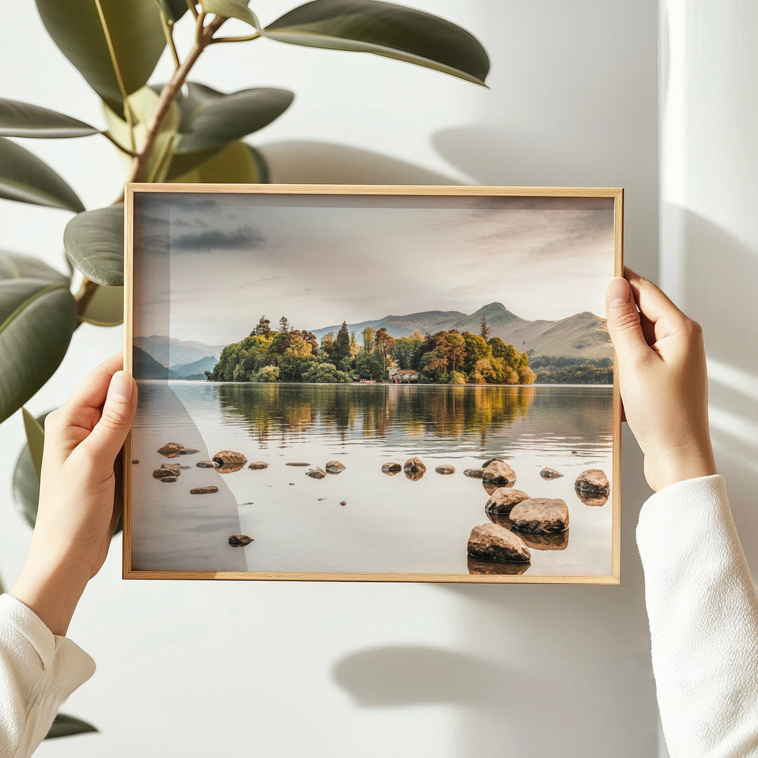 Woman holding framed Derwentwater print in soft morning light