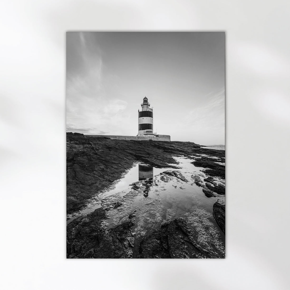 Monochrome fine art photo of Hook Head Lighthouse with rocky coastline