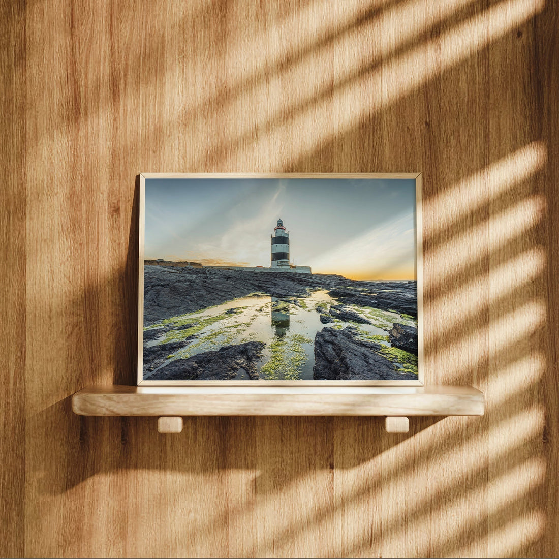 Irish lighthouse print featuring Hook Head on textured black rocks.