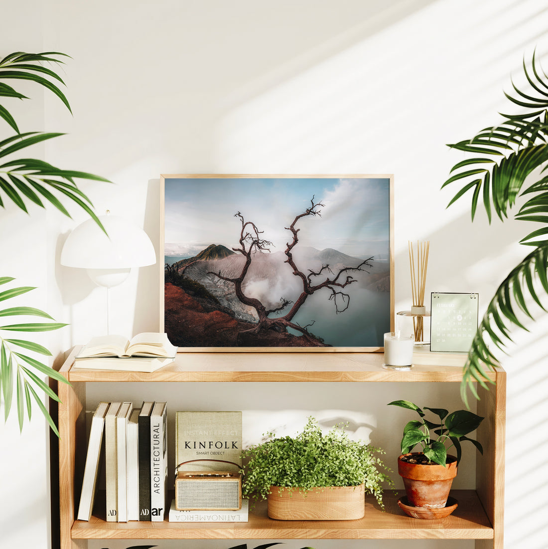 Ijen volcano dead tree crater lake large framed wall art print in natural wood frame on bookshelf with plants and Kinfolk book