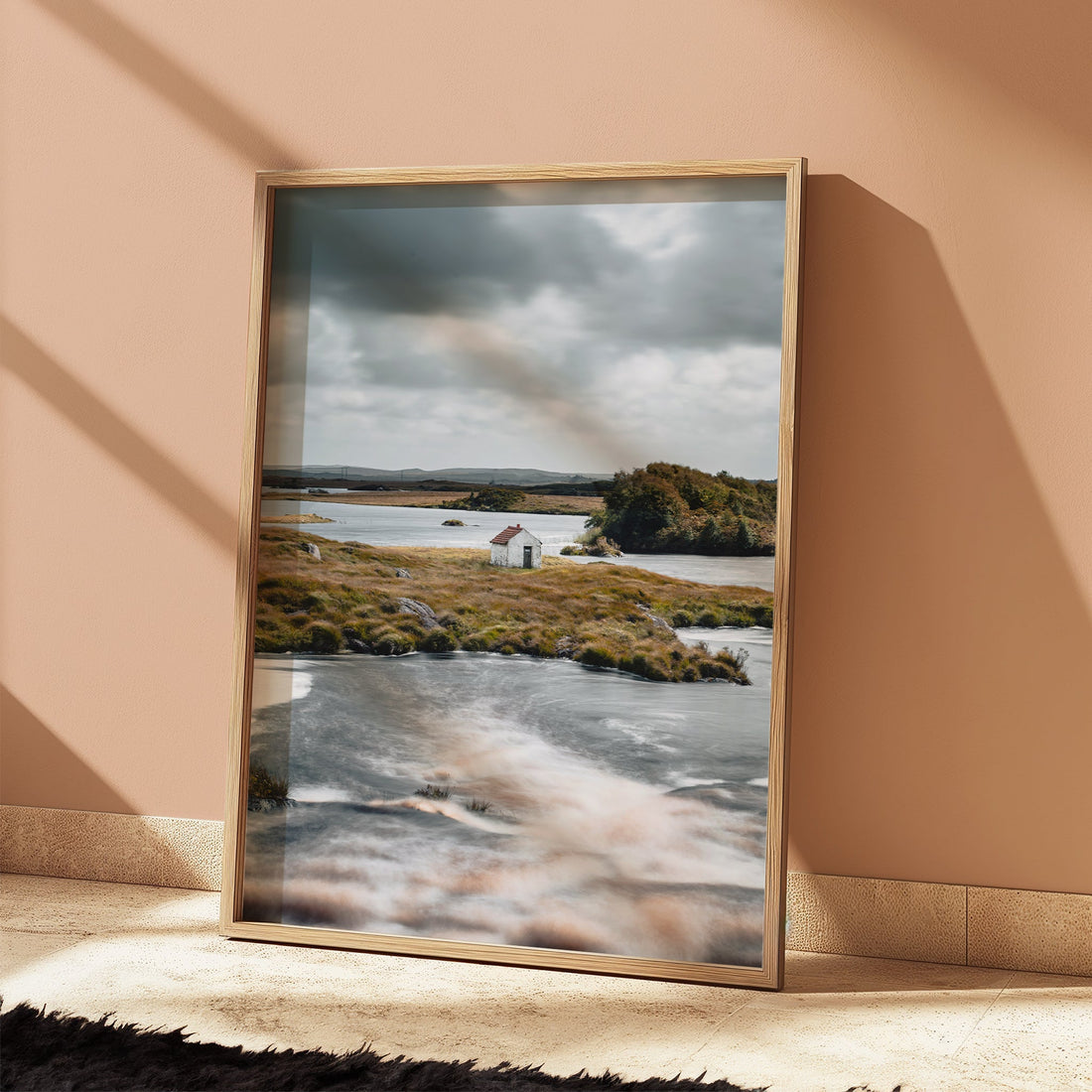 Warm-toned room showcasing an Ireland landscape print of a hut on a river island
