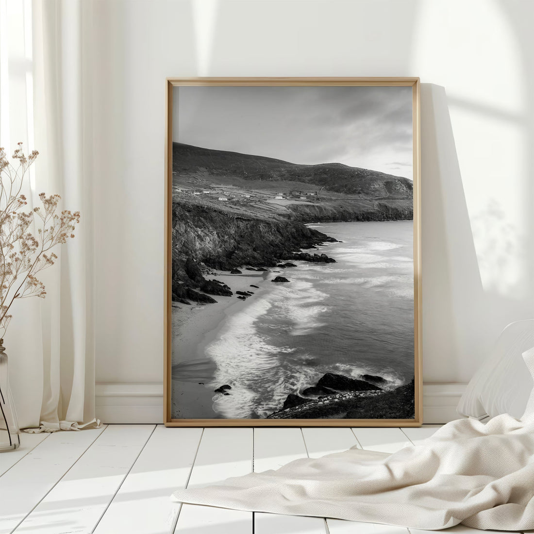 Black and white seascape print of Coumeenoole Beach displayed in a sunlit interior