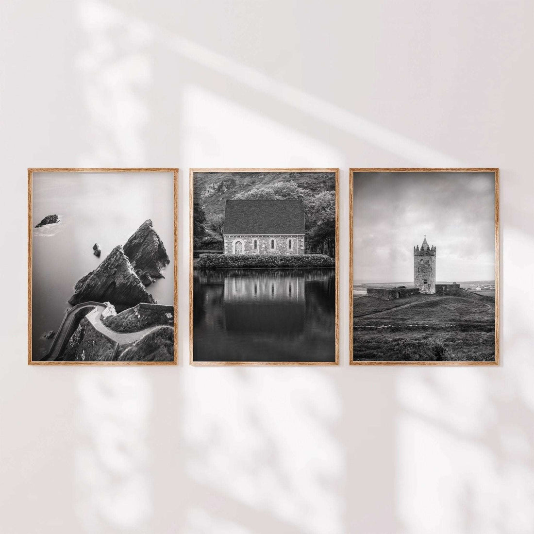 Minimalist display of three black and white Irish landscape prints in wooden frames arranged side by side.
