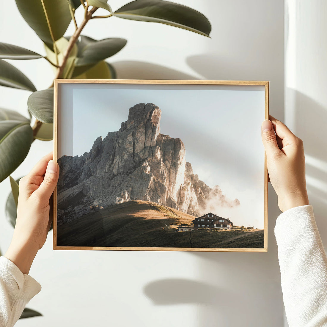 Hands holding a framed Passo Giau Dolomites photography print indoors