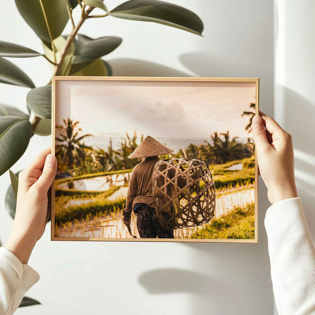 Person holding a natural wood framed print of a Balinese farmer at Jatiluwih Rice Terraces Bali