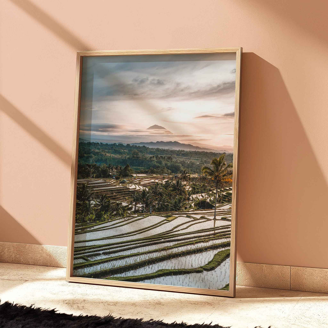 Jatiluwih rice terraces Bali sunset print with Mount Agung in natural wood frame leaning against peach terracotta wall