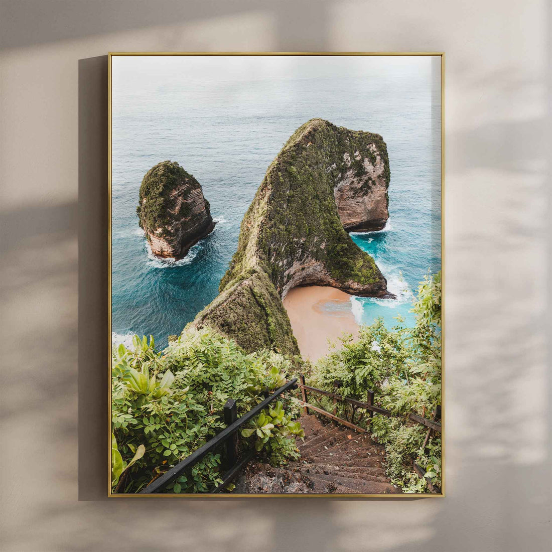 Kelingking Beach Nusa Penida wall art print in gold floating frame mounted on beige wall with natural shadows