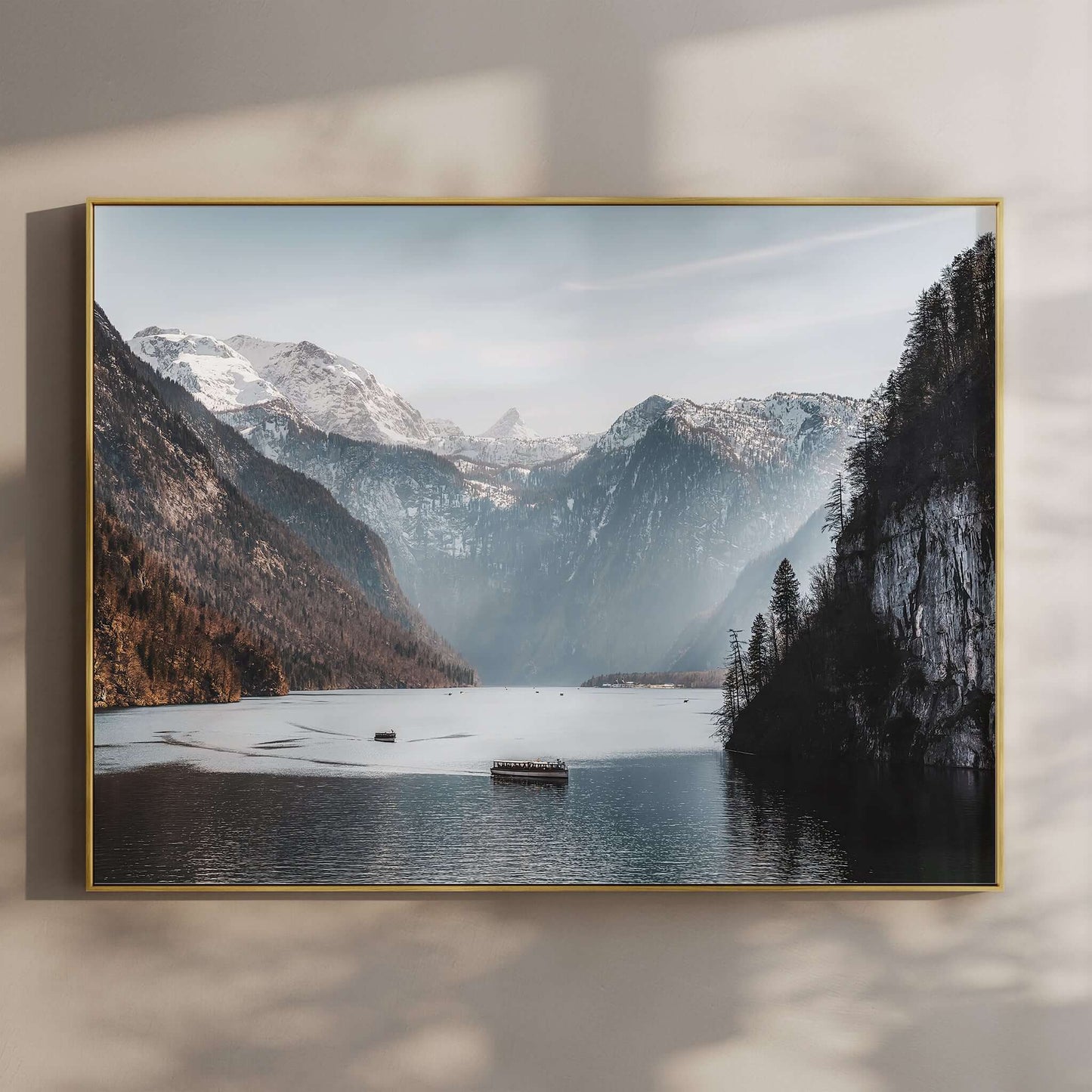 Boats on Königssee lake with alpine cliffs and snowy mountains in Bavaria