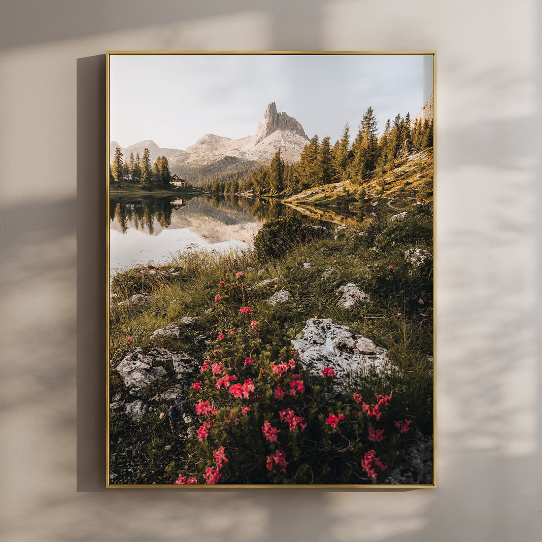 Sunrise over Lago di Federa with pink alpine flowers and mountain reflections