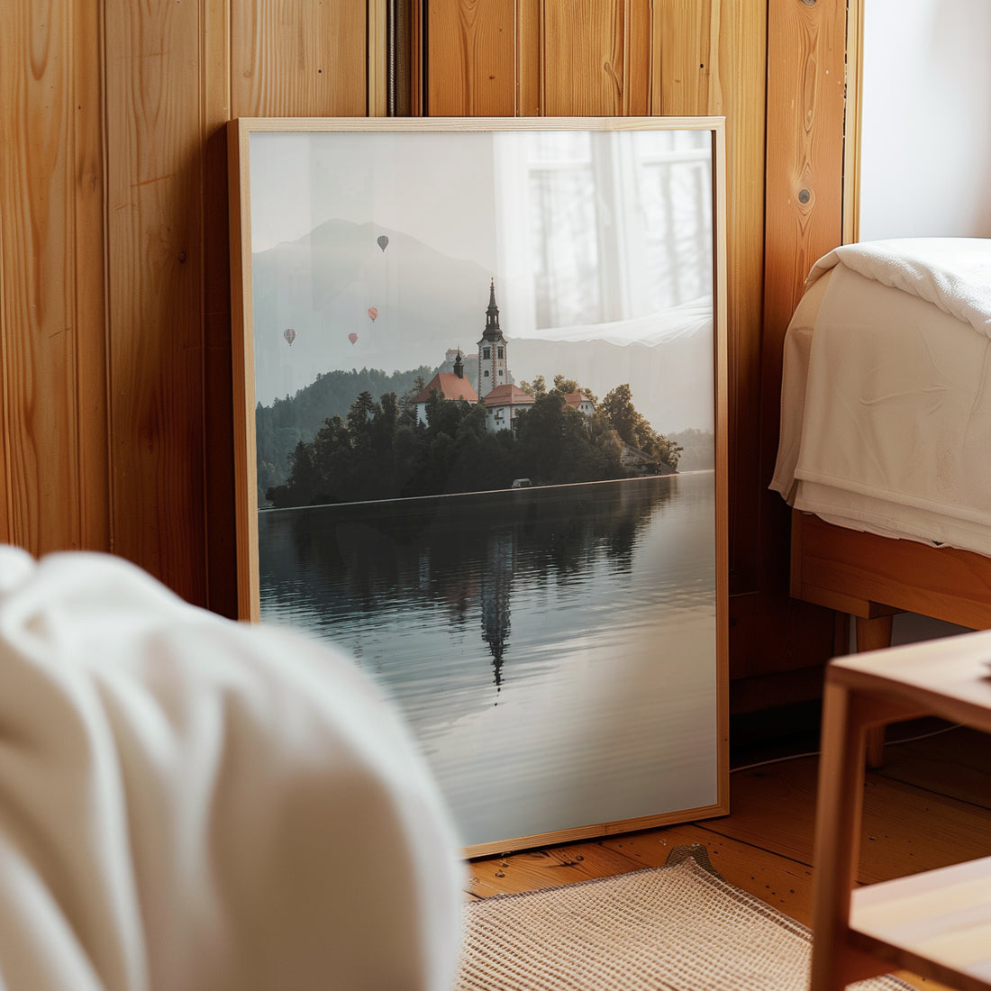 Lake Bled photo print placed on wood shelf in soft warm lighting