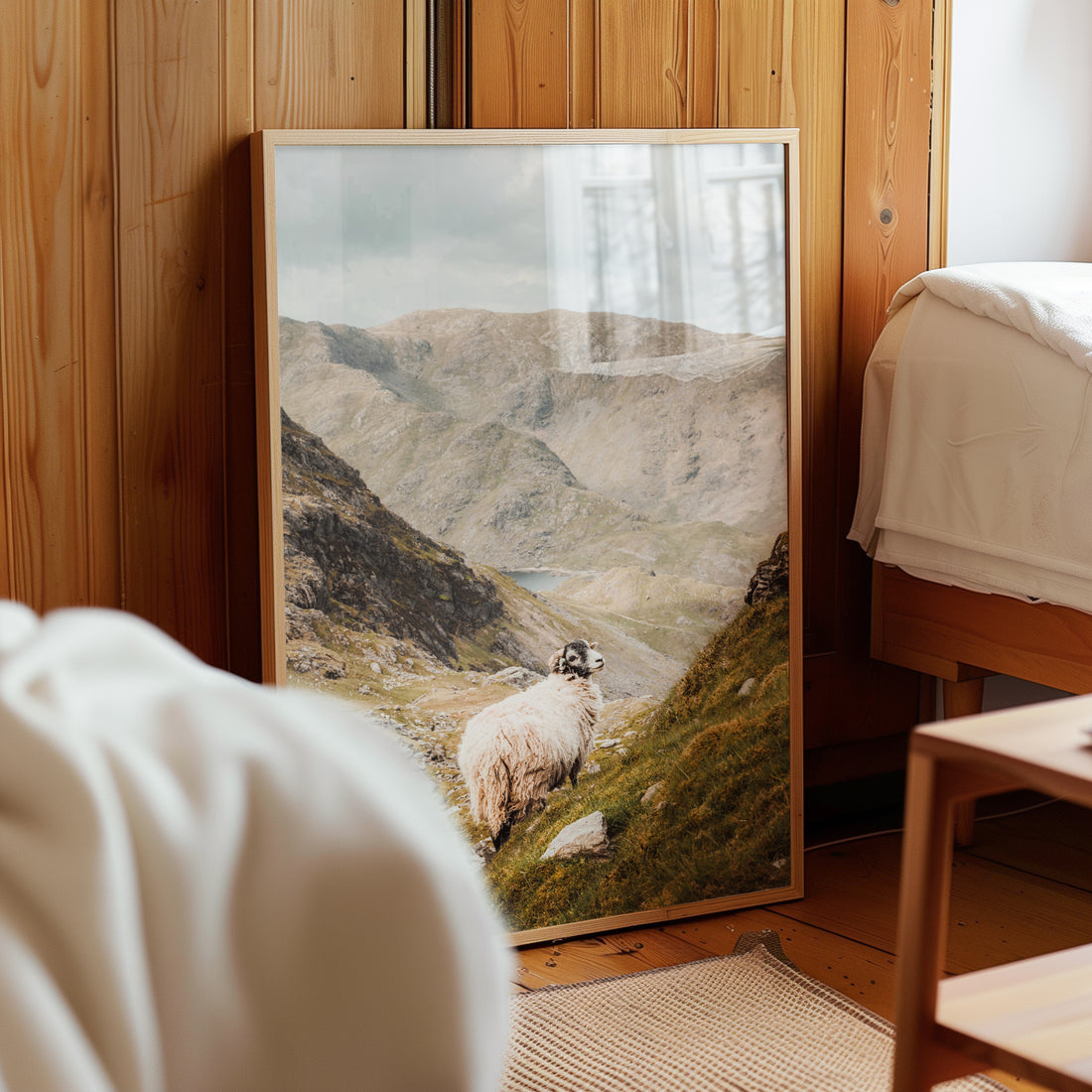A Lake District fine art print of the Old Man of Coniston resting against a wooden bedroom wall.
