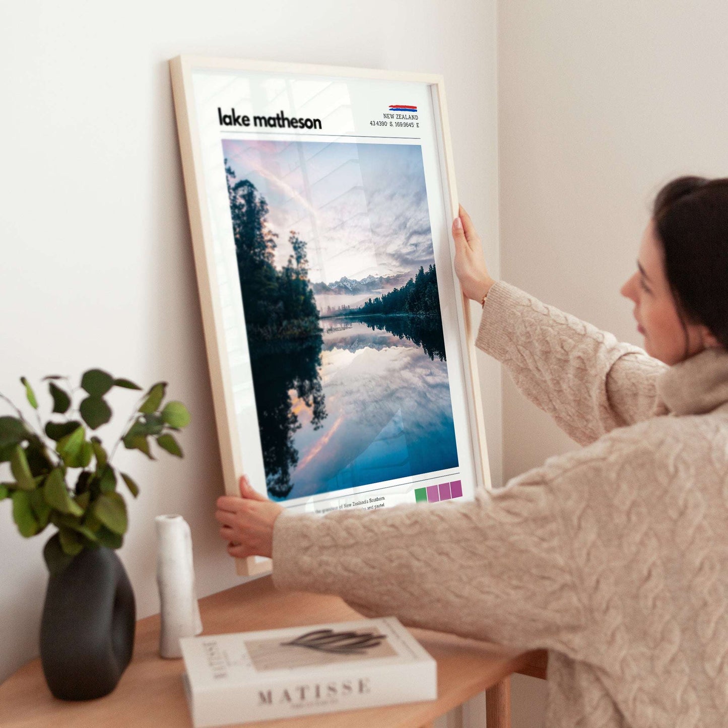 Framed Lake Matheson wall art print being placed on a shelf