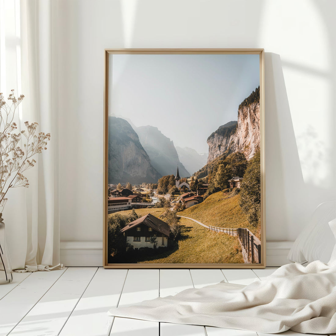 Scenic photography print of Lauterbrunnen Valley, Switzerland, with towering cliffs and a church.