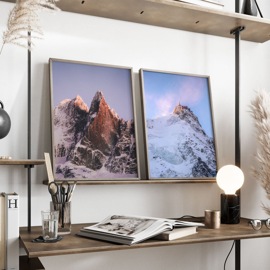 Framed Les Drus and Aiguille du Midi prints styled on a modern shelf with natural decor.