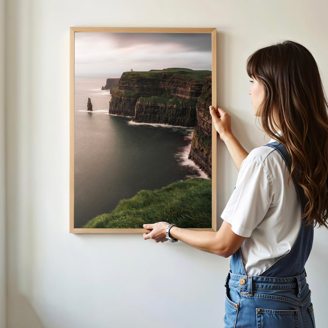 Framed Cliffs of Moher wall art being hung on a wall