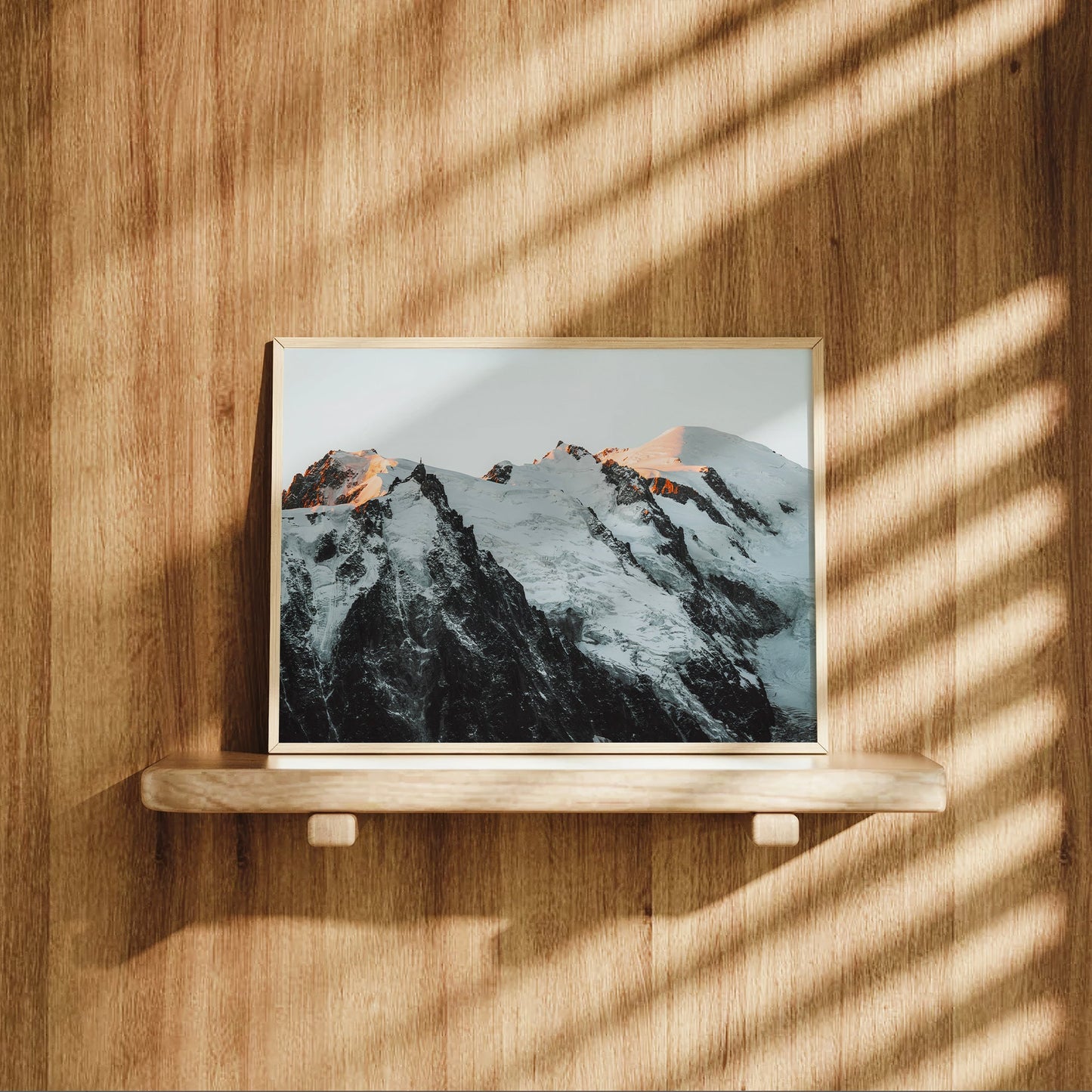 Landscape photo of the Mont Blanc Massif bathed in alpine light with sharp peaks and glacial shadows.