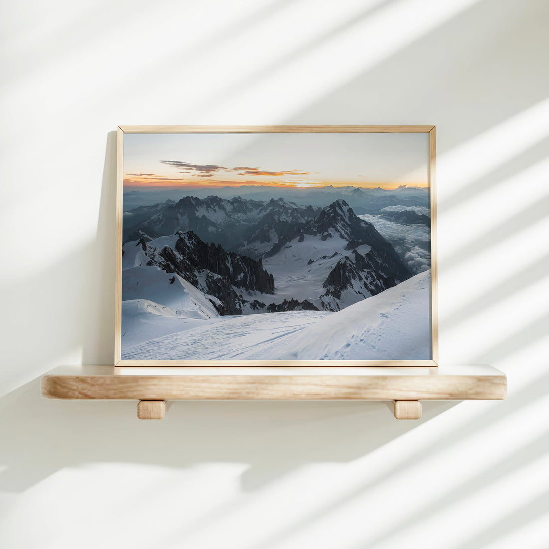 Serene landscape photo of Mont Blanc summit at dawn with snowfields and distant mountain silhouettes.