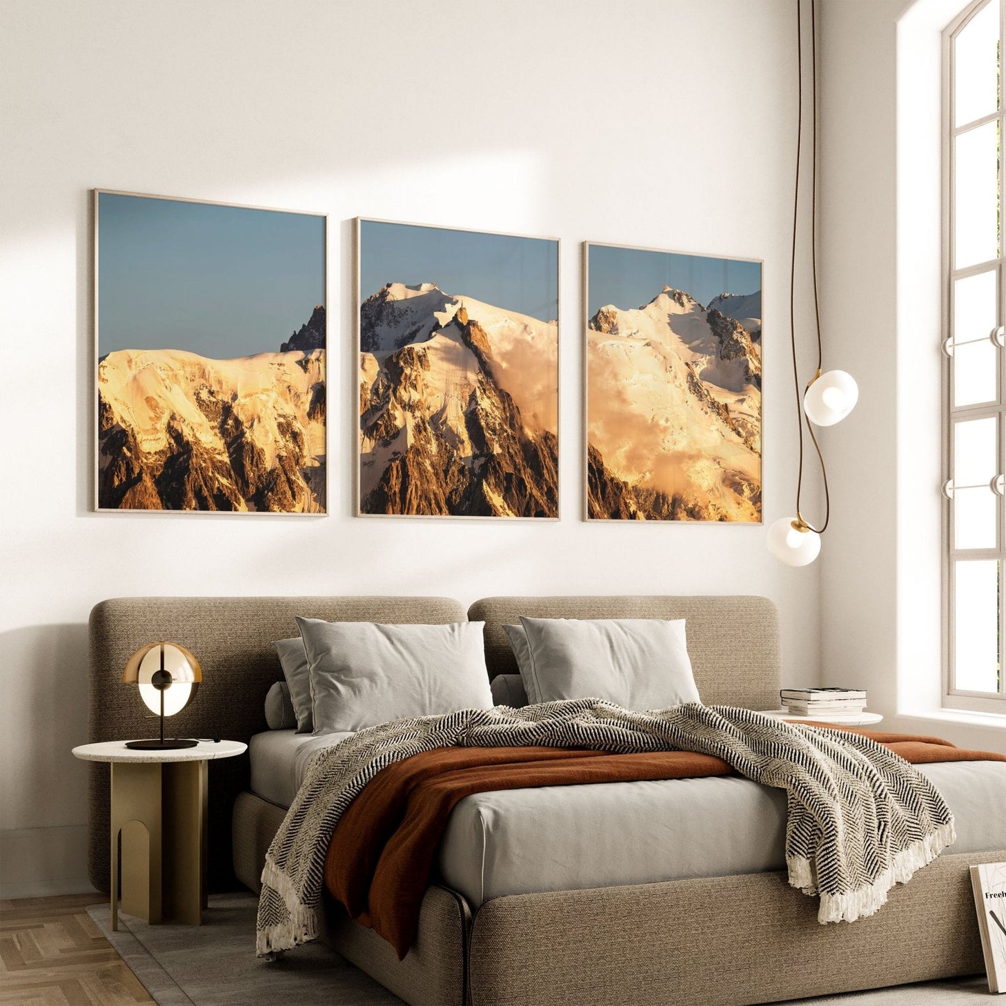 Three framed prints of Mont Blanc sunrise displayed above a modern bedroom setting, creating a serene and elegant ambiance.