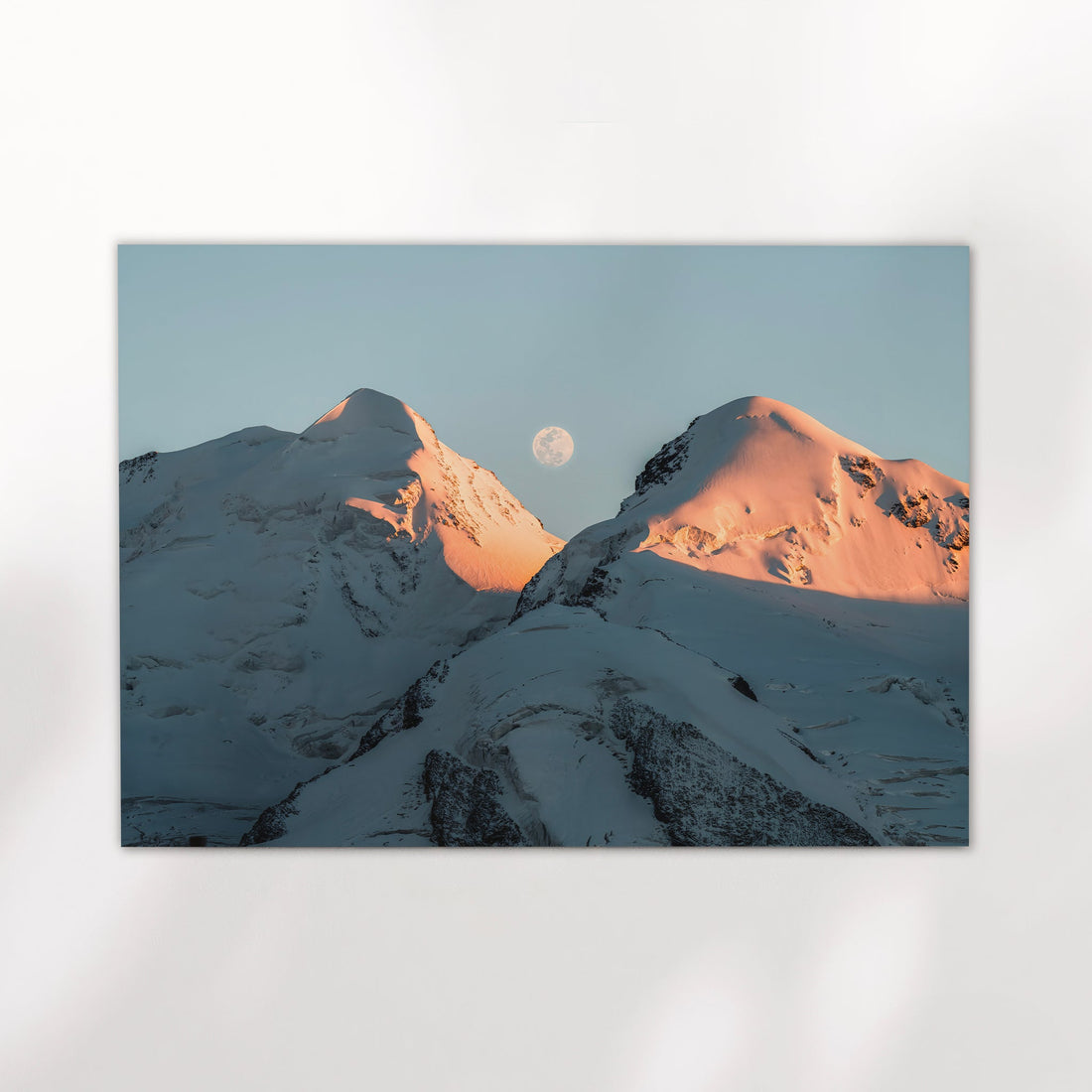 Alpine photography print showing the moon rising between snow-covered Castor and Pollux peaks at golden hour.